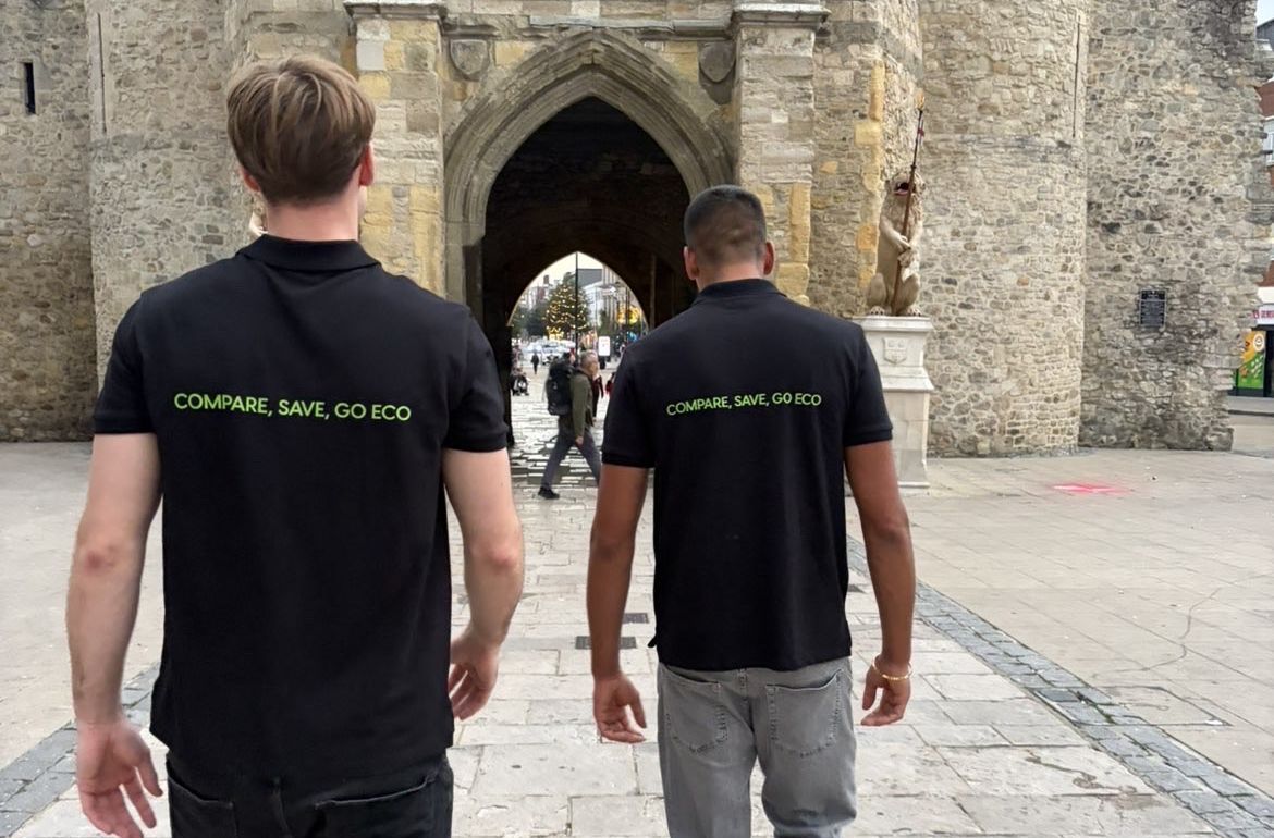 EcoCompare co-founders Rishi and Adam walking towards the Bargate in Southampton, wearing black polos printed with Compare, Save, Go Eco